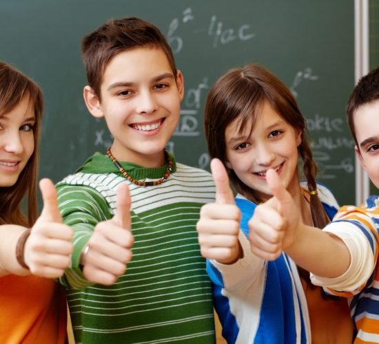 Portrait of happy teens showing thumbs up